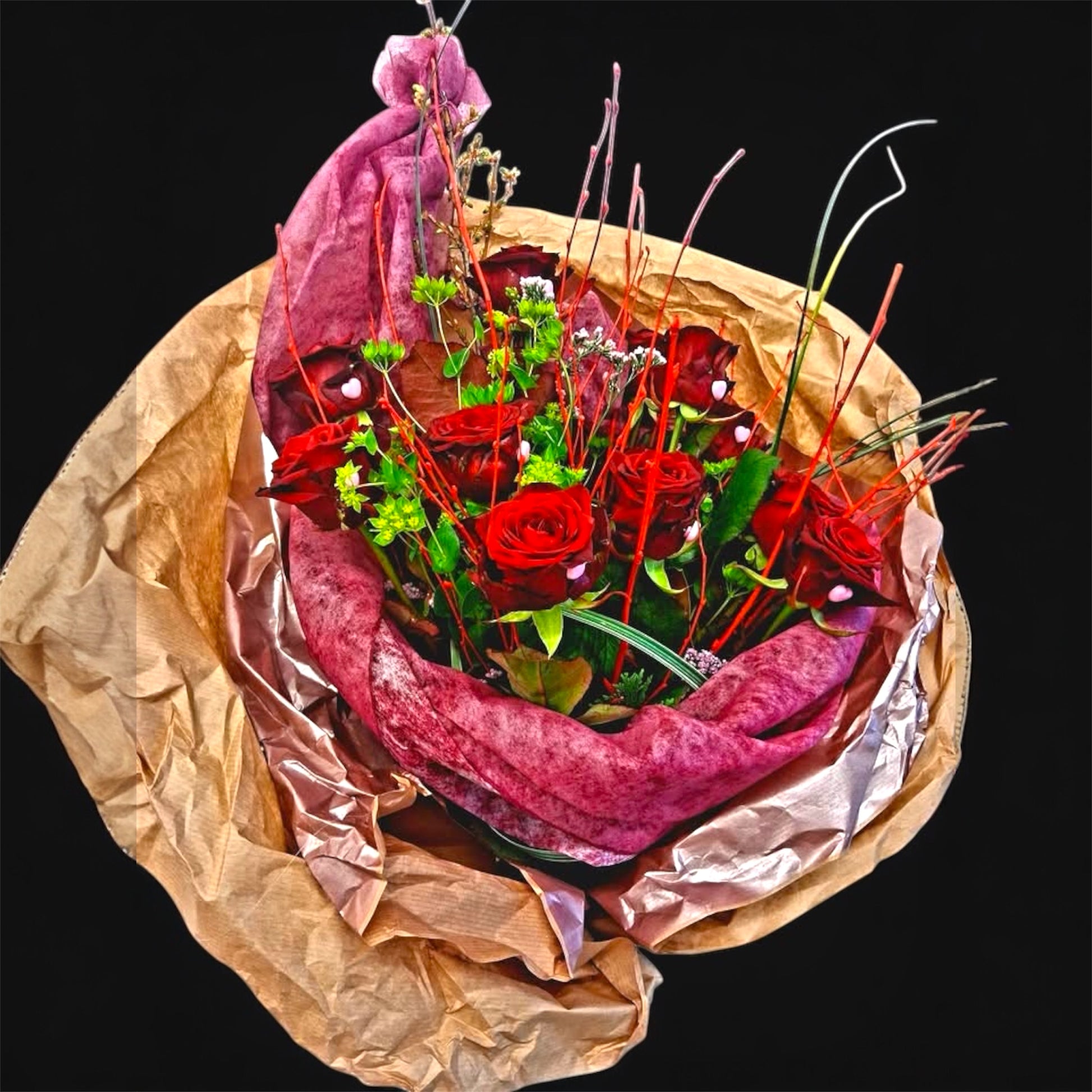 A Valentine’s bouquet built around deep red roses.